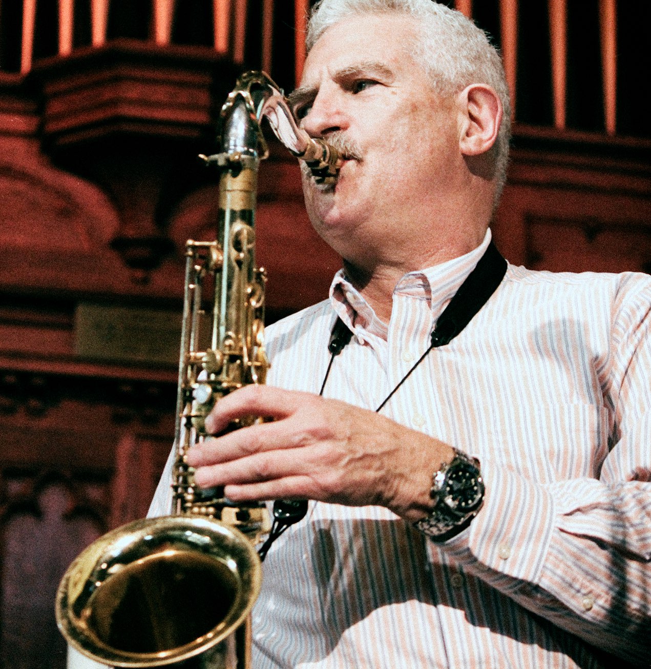 A saxophonist from the Cracked Pots performing in front of the pipe organ at Central United Church.